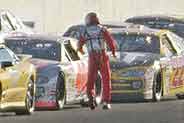 Sterling Marlin heads back to his car after trying to pull his right front fender away from his tire during a red flag. Credit: AP